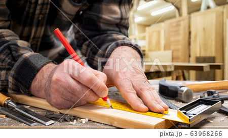 Carpenter at work on wooden boards. Carpentry. 63968266