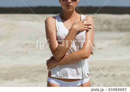 Seductive female on windy day on beach Seductive female on windy day on beach 63968897