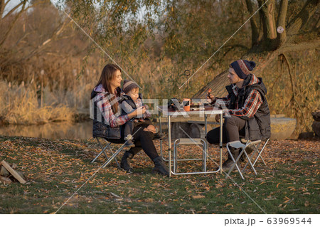 Cute family sitting on a picnic in a forest 63969544