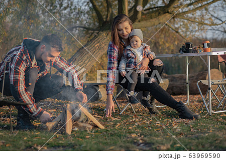 Cute family sitting on a picnic in a forest Cute family sitting on a picnic in a forest 63969590