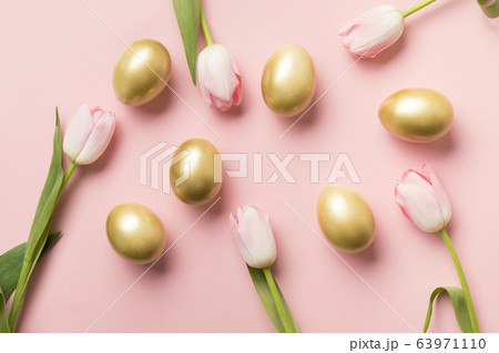 Easter golden eggs and pink tulips on pink paper 63971110