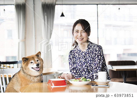 ドックカフェ 女性 犬 カメラ目線の写真素材