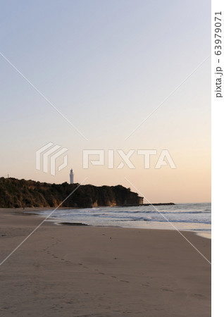 朝焼けの灯台の見える砂浜の風景 朝焼けの灯台の見える砂浜の風景 63979071