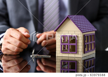 Man in suit and tie and silver key closeup Man in suit and tie and silver key closeup 63979388