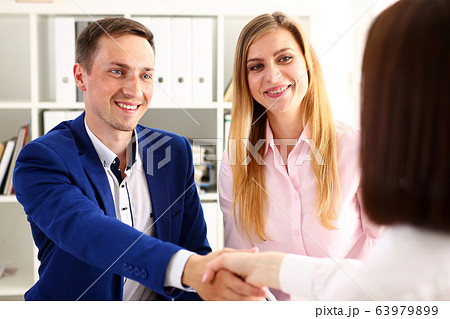 Smiling man and woman shake hands as hello in office 63979899