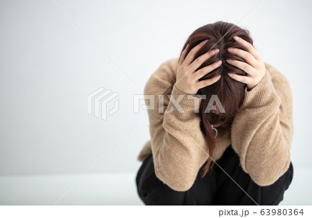 私服の女性が頭を抱えている 悲しい sad 私服の女性が頭を抱えている 悲しい sad 63980364