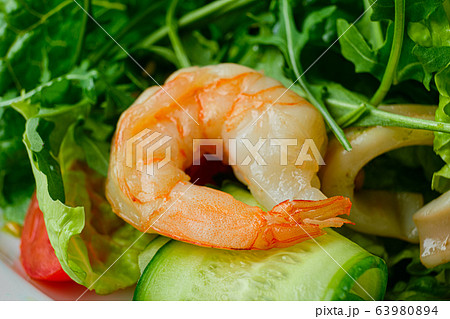 Macro photo of shrimp in salad with cucumber, arugula and pine nuts 63980894