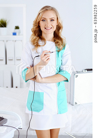 Portrait of professional female beautician standing straight in beauty salon. Makeup artist ready to do eyebrow permanent tattoo at any woman face. 63982259