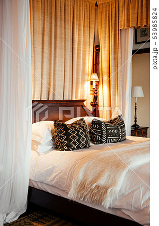 Contemporary vintage hotel bedroom with wooden four poster bed Contemporary vintage hotel bedroom with wooden four poster bed 63985824