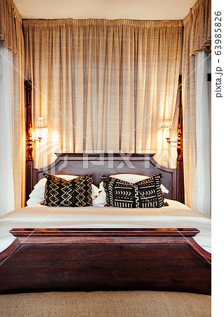 Contemporary vintage hotel bedroom with wooden four poster bed Contemporary vintage hotel bedroom with wooden four poster bed 63985826