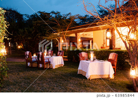 Luxury African Safari lodge outdoor dining on grass lawn Luxury African Safari lodge outdoor dining on grass lawn 63985844