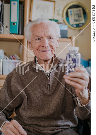 Senior man holding bottle with Pills closeup Senior man holding bottle with Pills closeup 63987362