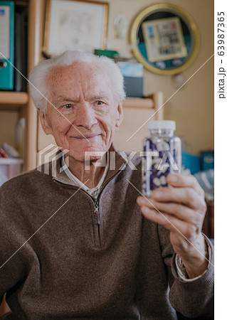 Senior man holding bottle with Pills closeup 63987365