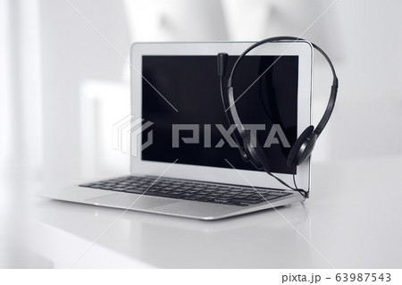 Call center and communication support, customer service help desk. VOIP headset on laptop computer 63987543