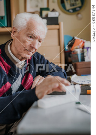 Senior arranges medicines for each day of week 63987544