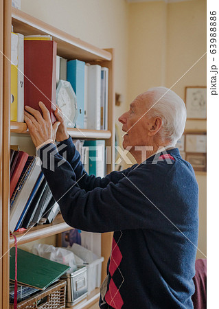 Elderly man reading book at home Elderly man reading book at home 63988886