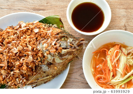 batter fried mango fish topping chop garlic dipping sweet and soy sauce  63993929