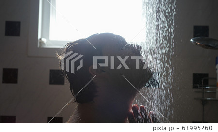 Handsome man in shower washing hair showering in bathroom 63995260