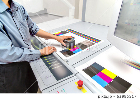 オフセット印刷において印刷物の濃度を測定する手元のアップ。カラーマネージメント、品質管理イメージ 63995517