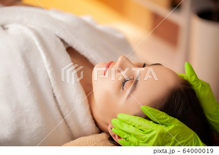 Pretty woman receiving facial massage in spa salon Pretty woman receiving facial massage in spa salon 64000019