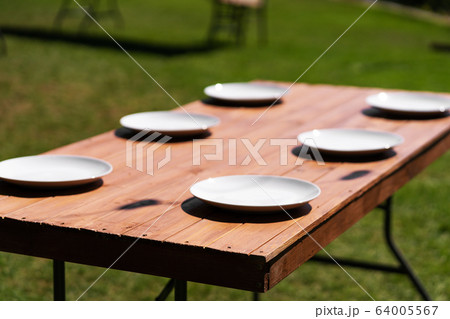 White plates are placed on a wooden table in the 64005567