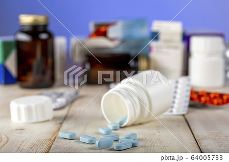 Home therapy. Open bottle with blue pills. Home therapy. Open bottle with blue pills. 64005733