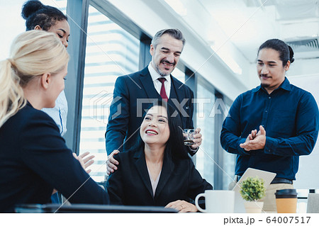 Business woman have praised by colleagues in team. 64007517