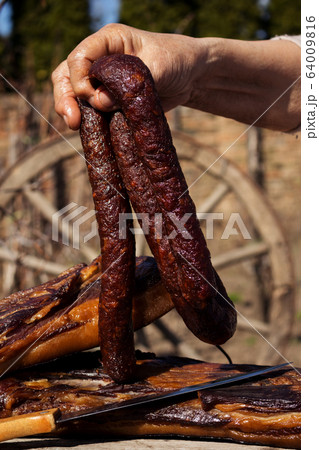 Smoked Dried Sausages Held By Woman's Hand  64009816