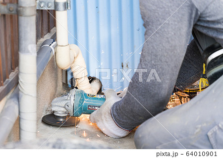 ディスクグラインダーでコンクリートを削っている職人 64010901