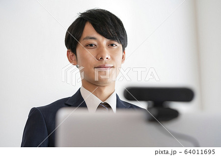 ウェブカメラを使ってオンライン面接を受ける若い男性　イメージ 64011695