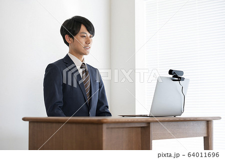 ウェブカメラをセットしたノートパソコンに向かう若い男性　就活イメージ 64011696