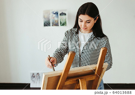 Young woman painting with watercolor at home studio 64013688