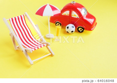 Deck chair with umbrella and car on yellow 64016048