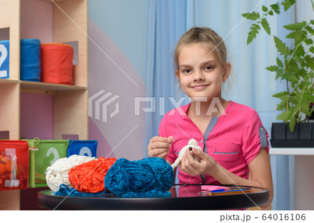 The girl is engaged in embroidery of soft toys at The girl is engaged in embroidery of soft toys at 64016106