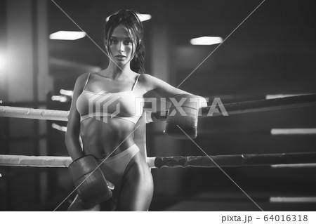 Female boxer posing near ring, monochrome. Female boxer posing near ring, monochrome. 64016318