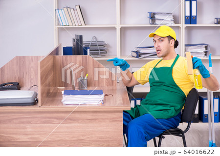 Young male contractor cleaning the office Young male contractor cleaning the office 64016622