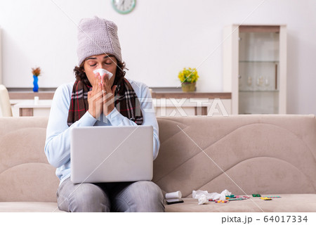 Young man suffering from flu at home 64017334