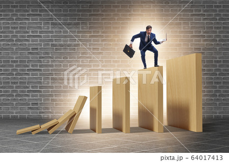 Businessman in domino effect concept Businessman in domino effect concept 64017413
