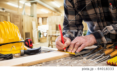 Carpenter at work on wooden boards. Carpentry. 64018333
