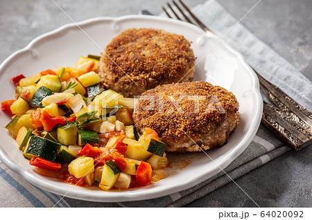 Minced beef cutlets served with and stewed vegetables. 64020092