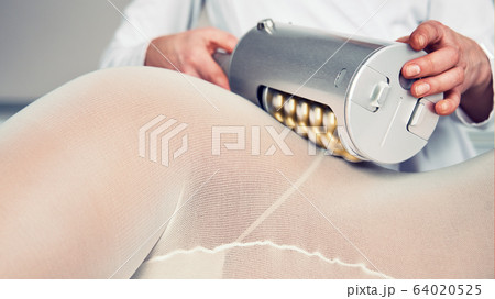 Masseur makes apparatus anti-cellulite massage in the cosmetology clinic Masseur makes apparatus anti-cellulite massage in the cosmetology clinic 64020525