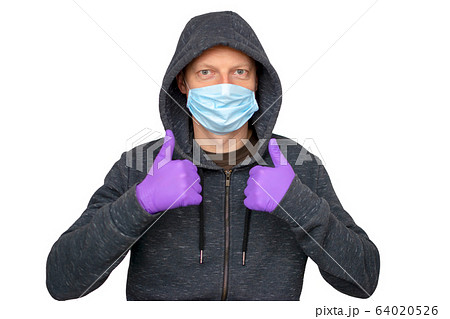 Caucasian man with beard protecting from the coronavirus with a mask and gloves over isolated background giving a thumbs up gesture 64020526