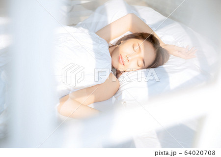 女性　綺麗　美人　起床　ベッド　寝室　日差し　朝 64020708