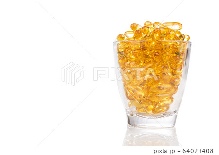 Glass filled with fish oil gel capsule containing omega-3 Glass filled with fish oil gel capsule containing omega-3 64023408