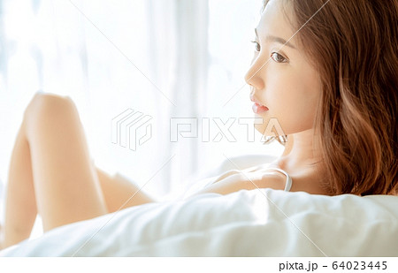 女性 美人 若い 綺麗 座る 横顔 朝の写真素材