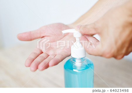 Women washing hands with alcohol gel or 64023498