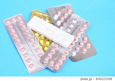Contraception pills and Pregnancy test on blue Contraception pills and Pregnancy test on blue 64023506