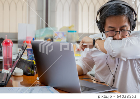 Businessman making video conference and sneezes into elbow. 64023553