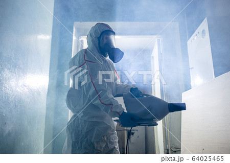 World pandemic COVID-19. disinfector in suit indoors World pandemic COVID-19. disinfector in suit indoors 64025465