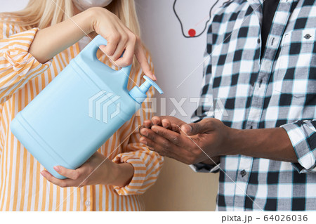 cropped people using spray for disinfection during coronavirus epidemic 64026036